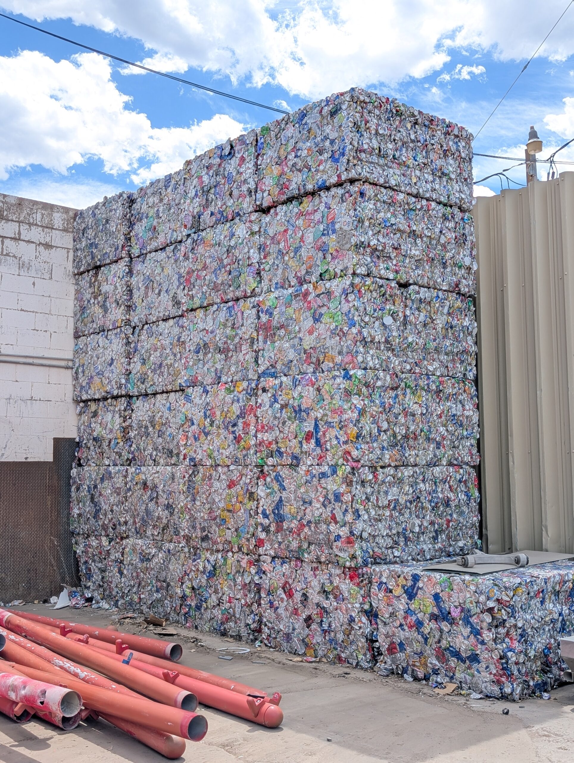 Stacked bales of crushed aluminum cans at a recycling facility, highlighting the importance of recycling and waste management efforts.