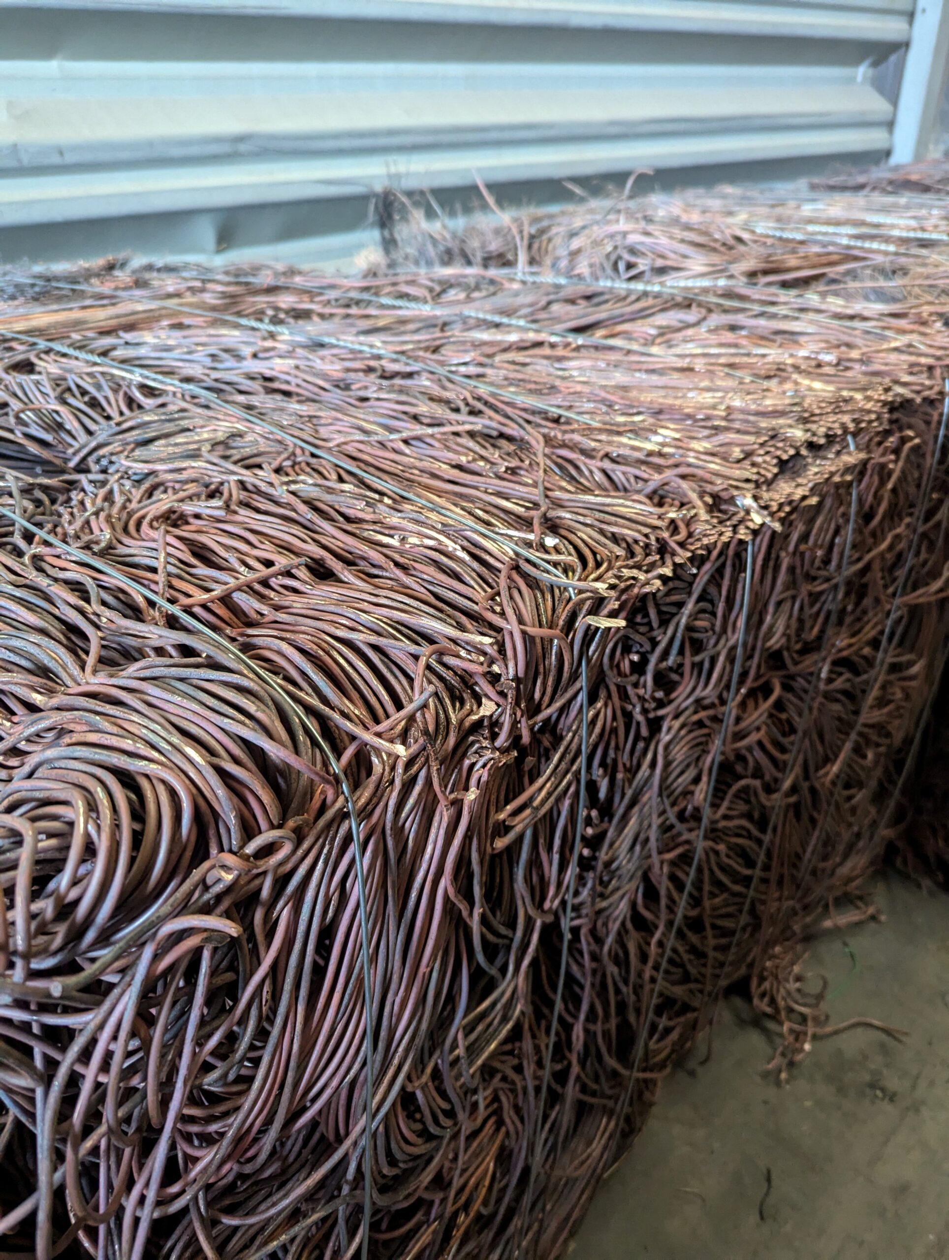 Bundled copper wires neatly arranged, showcasing their texture and metallic sheen. Relevant for discussions on recycling or metal materials.
